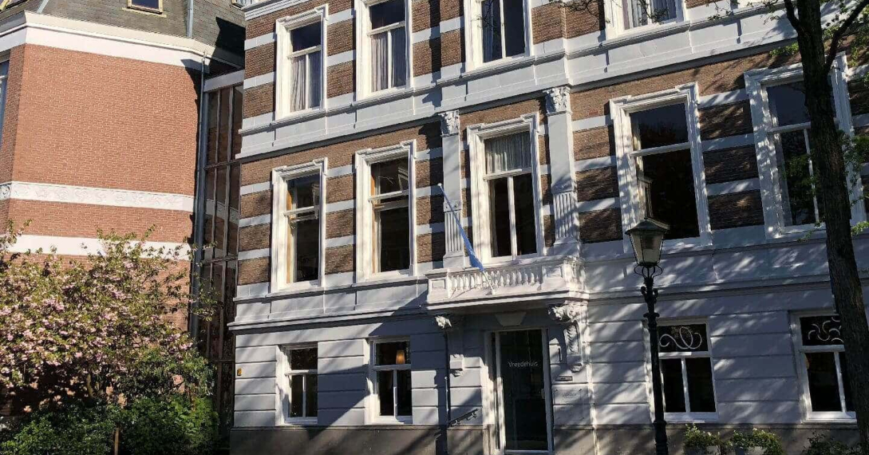 Een bruisend historisch gebouw met gevarieerde gevels en een blauwe lucht.