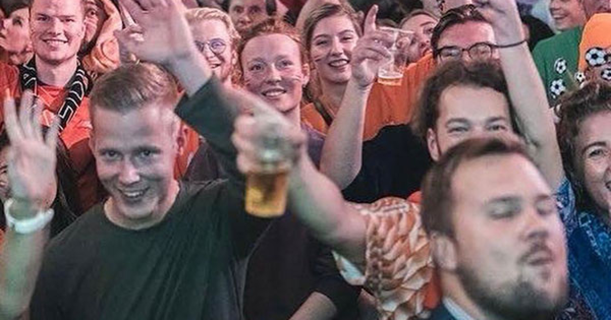 Een grote menigte in oranje kleding die feest viert.