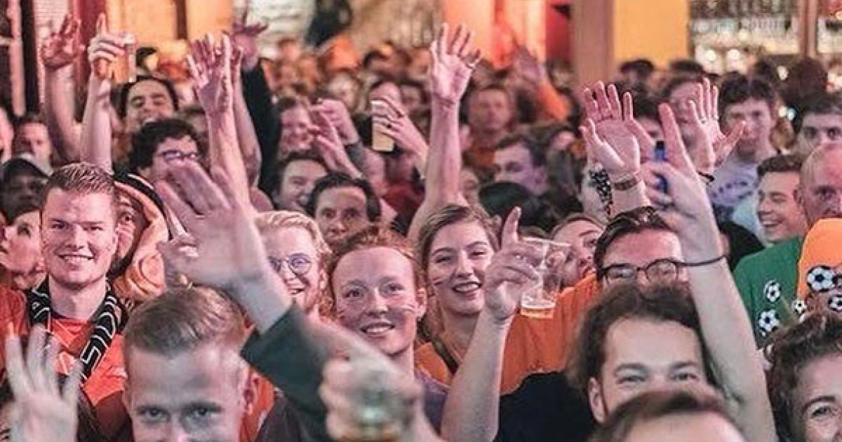 Een grote menigte in oranje kleding die feest viert.