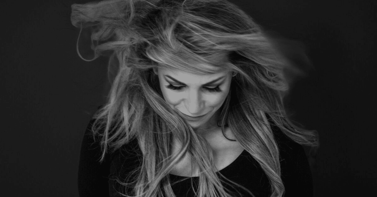 Vrouw met lang, wapperend haar kijkt naar beneden