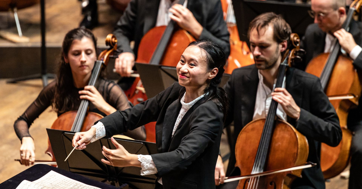 Vrouwelijke dirigent voor een orkest met cellisten