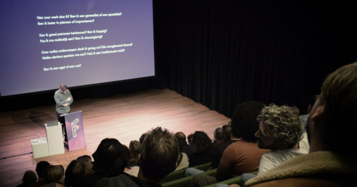 Spreker op filosofische avond in theaterzaal