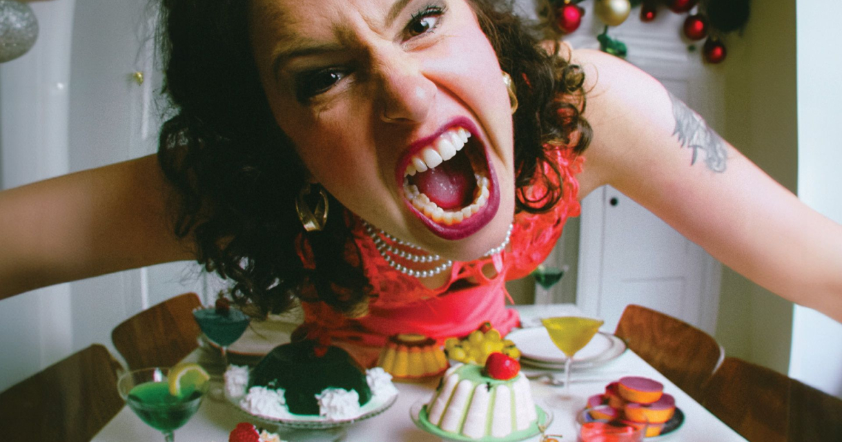 Boze vrouw buigt zich schreeuwend over dinertafel Boze vrouw buigt zich schreeuwend over dinertafel
