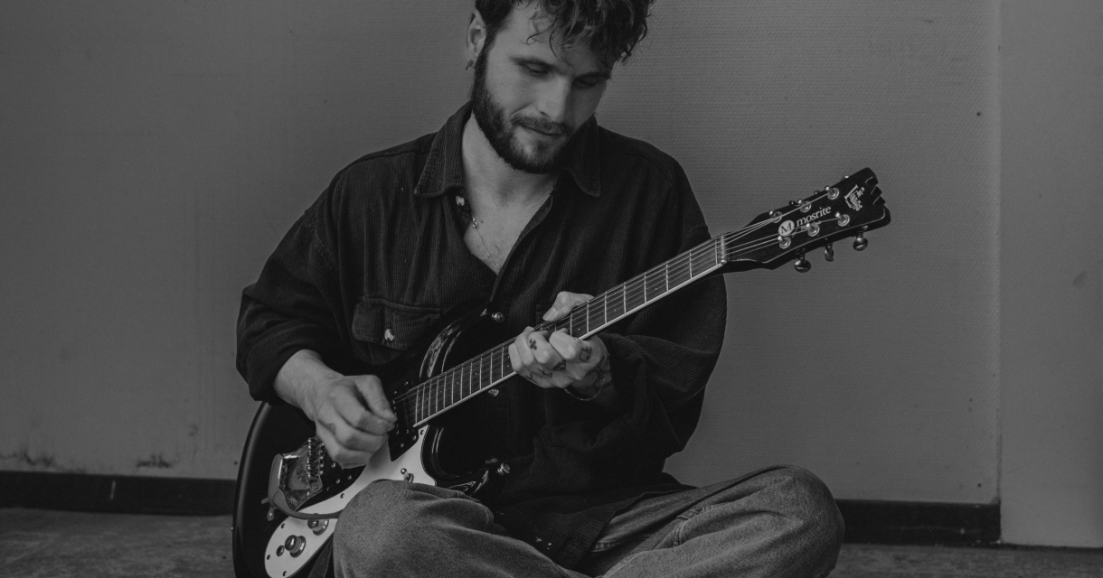 Muzikant speelt elektrische gitaar op een klein podium tijdens een intiem optreden