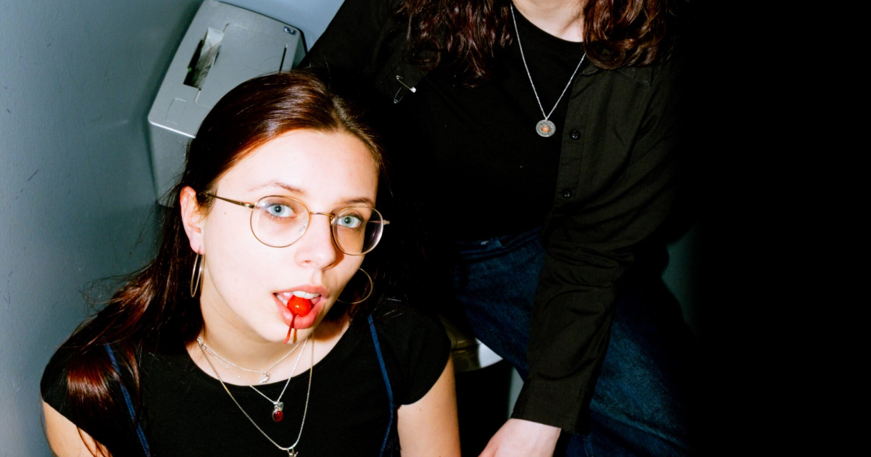DJ-duo GirlsSuck achter de draaitafels tijdens een donkere clubnacht met glitter en publiek