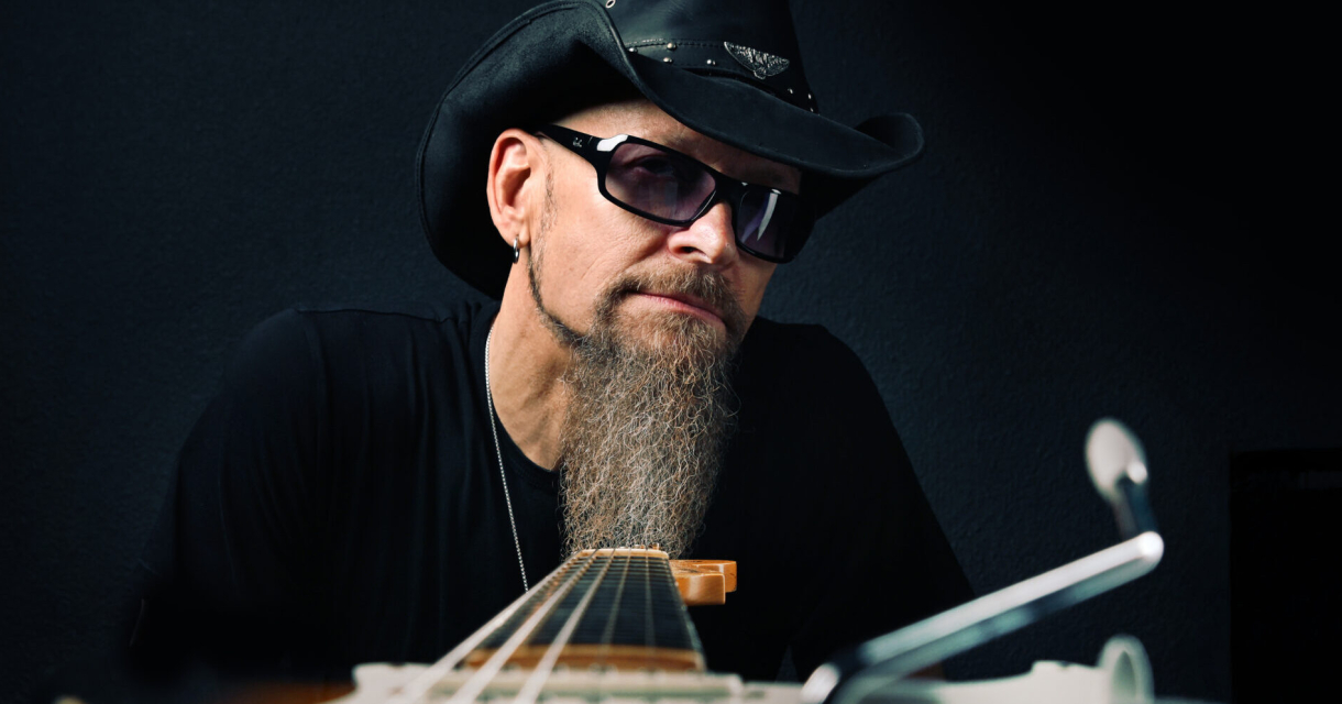 Dudley Taft playing electric guitar on stage at a blues rock concert