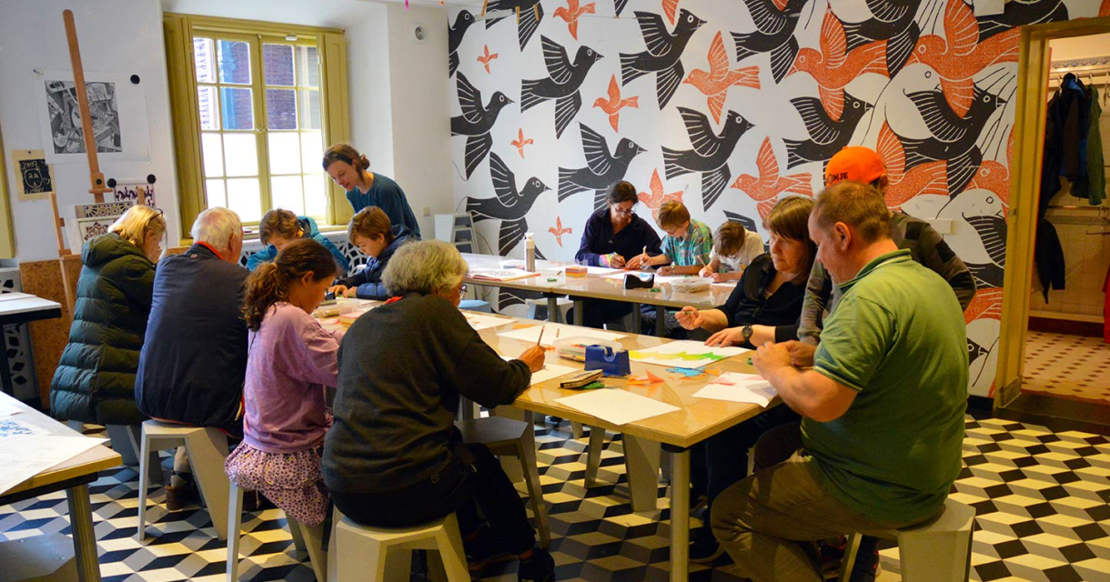 Child creating a tessellation on paper in the Escher atelier