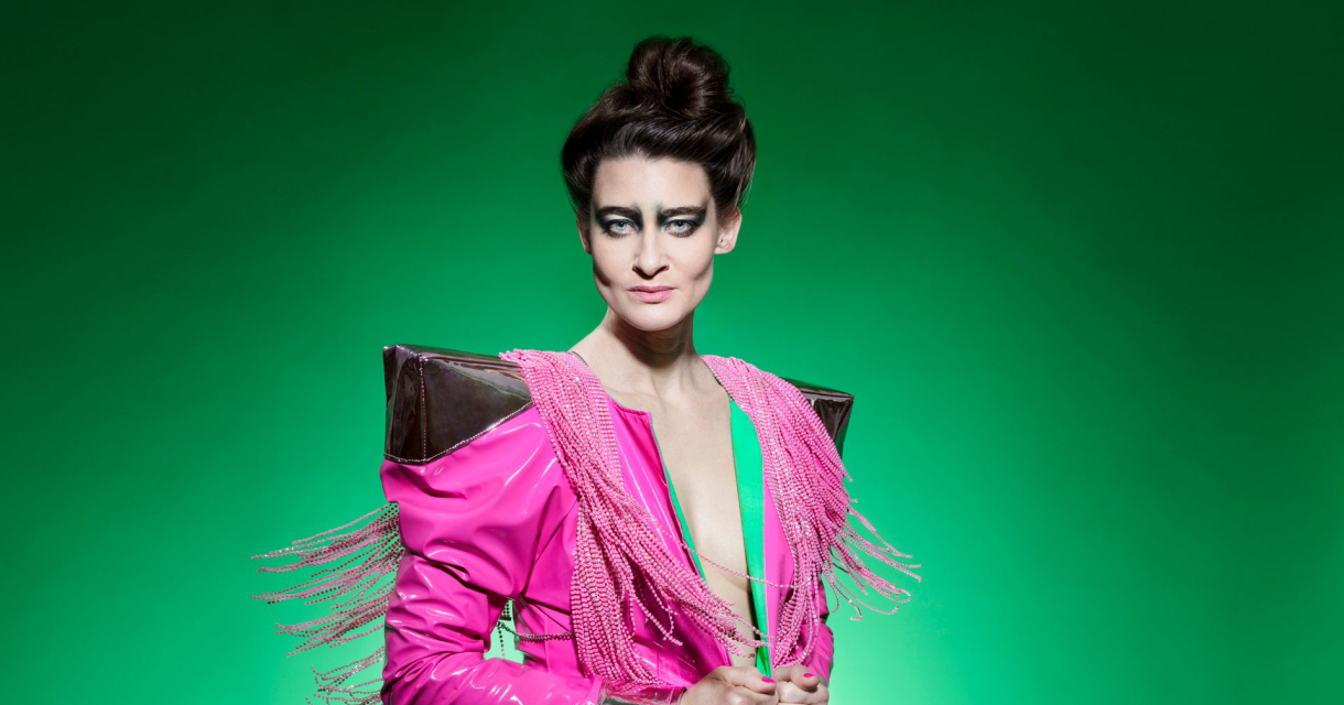 Vrouw in felroze futuristisch kostuum met franjes Vrouw in felroze futuristisch kostuum met franjes
