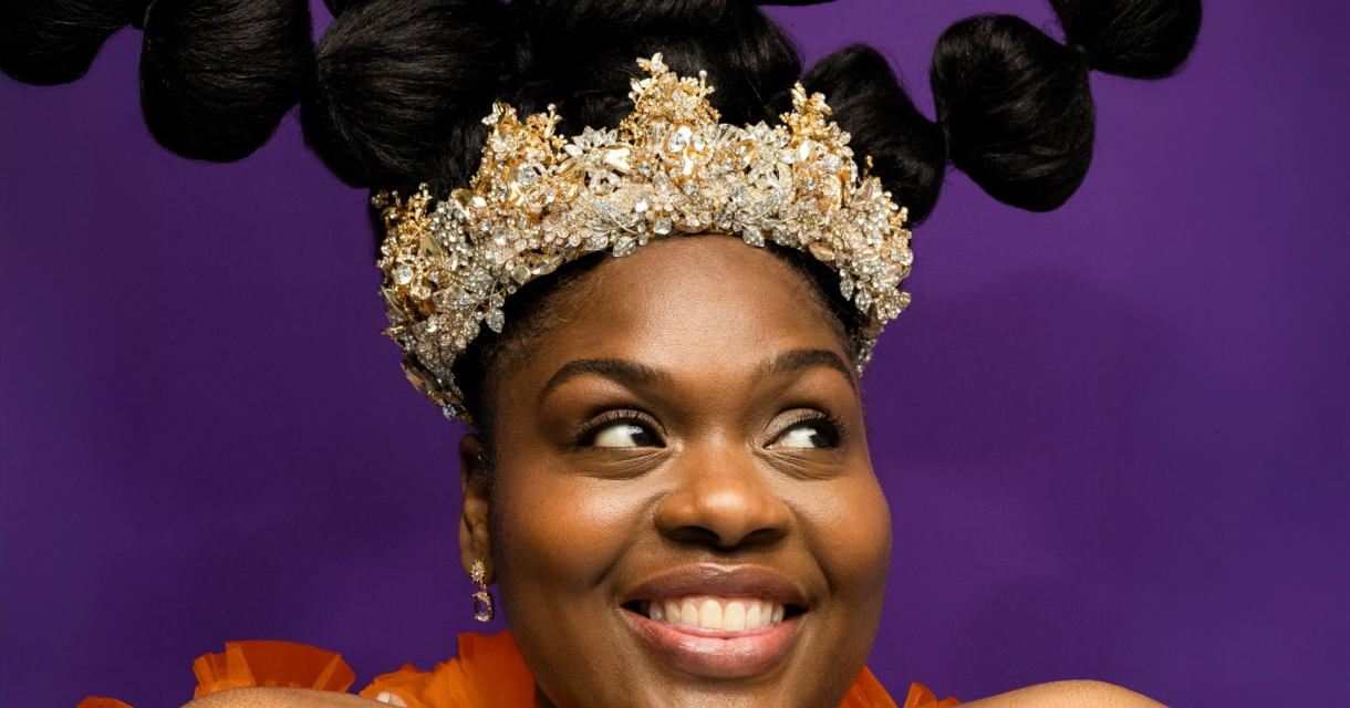 Lachende vrouw met kroon en creatief opgestoken haar Lachende vrouw met kroon en creatief opgestoken haar