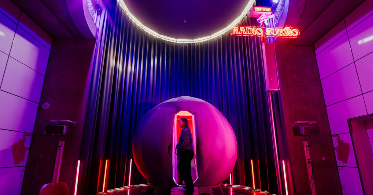 Persoon stapt futuristische radiocabine binnen in neonlicht Persoon stapt futuristische radiocabine binnen in neonlicht