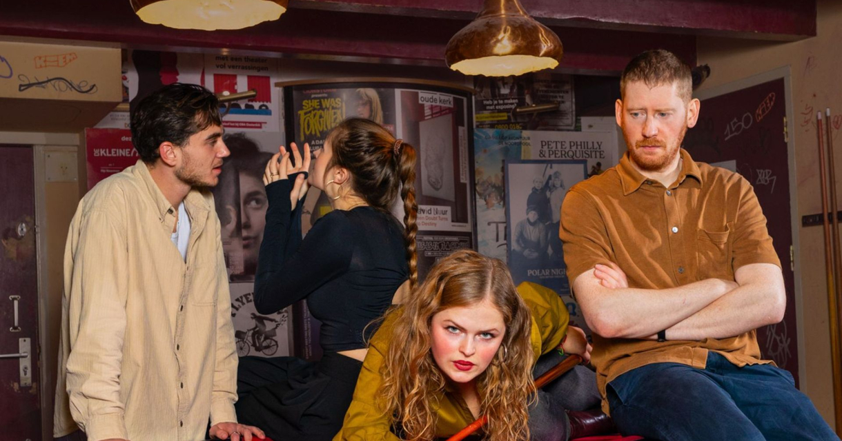 Vier jonge mensen in spanningsvolle caféscène Vier jonge mensen in spanningsvolle caféscène