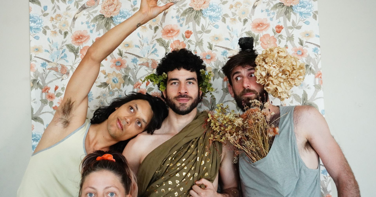 Vier personen in speelse poses voor bloemrijk behang, deels versierd met planten, droogbloemen en creatieve kledingcombinaties. Vier personen in speelse poses voor bloemrijk behang, deels versierd met planten, droogbloemen en creatieve kledingcombinaties.