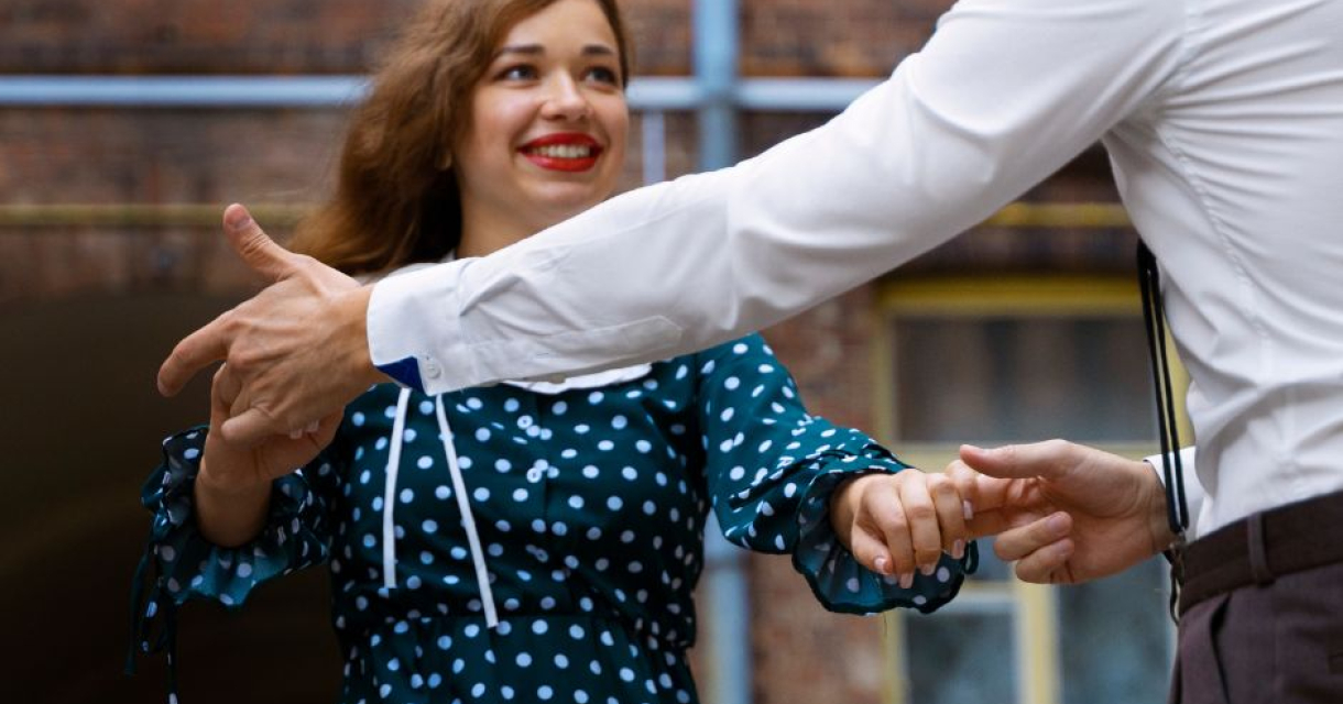 Danskoppel met de vrouw in beeld die een blauwe stippenjurk draagt Danskoppel met de vrouw in beeld die een blauwe stippenjurk draagt