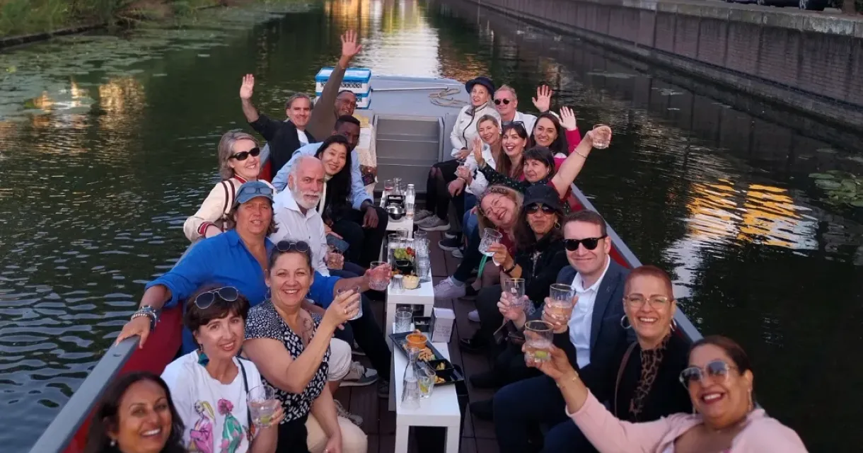 Groep mensen die varen over een gracht terwijl ze proostend naar de camera kijken. Groep mensen die varen over een gracht terwijl ze proostend naar de camera kijken.
