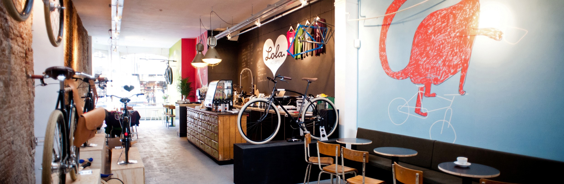 Industriele interieur van Lola bikes & coffee Den Haag met koffiebar en fietsen aan de muur