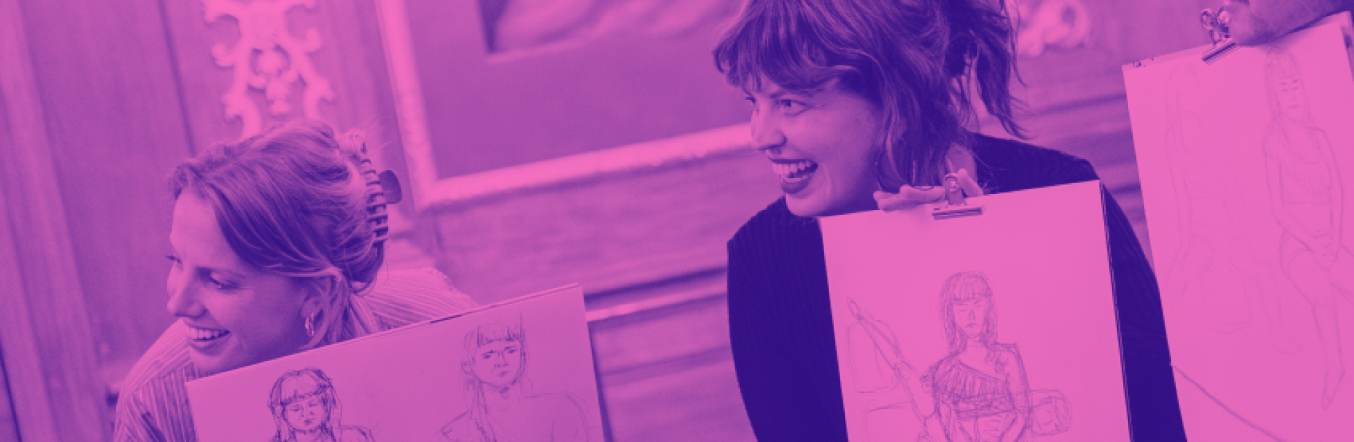 Drie vrouwen lachen en tonen hun tekeningen in een creatieve setting.