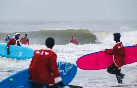 Trotseer de golven van de Noordzee tijdens Surfin Santa's (c) Wouter de Wolf 