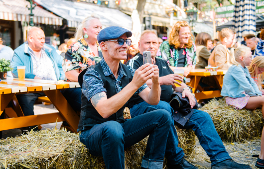 Een bezoeker zittend op een hooibaal tijdens Wild Rooster Festival (c) Parcifal Werkman
