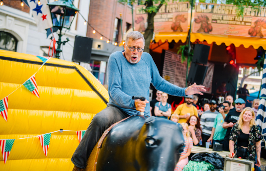 Een bezoeker die een ritje maakt op de mechanische stier (c) Parcifal Werkman
