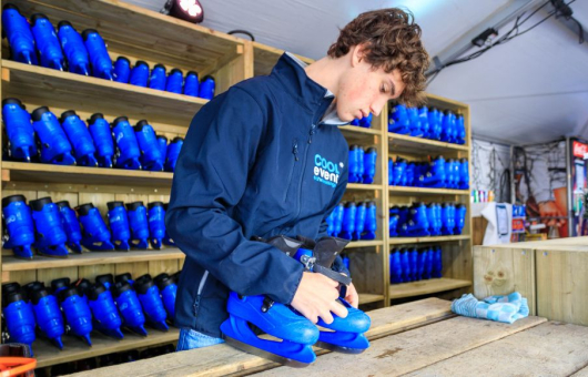 Jongen maakt schaatsen gereed voor gebruik
