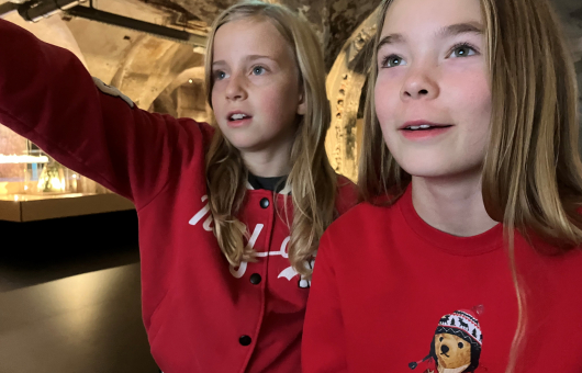 Twee meisjes die geconcentreerd een videospel spelen bij IBR
