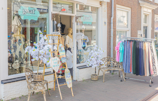 Winkel in de Keizerstraat met vrolijke artikelen en een kledingrek