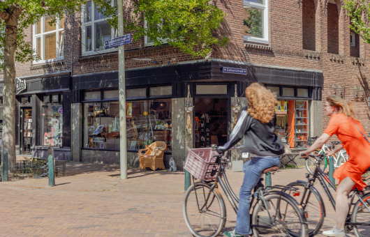 Twee dames fietsen door de Fahrenheitstraat in Den Haag