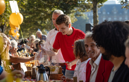 Vrijwilliger serveert ontbijt tijdens het PrinsjesOntbijt 