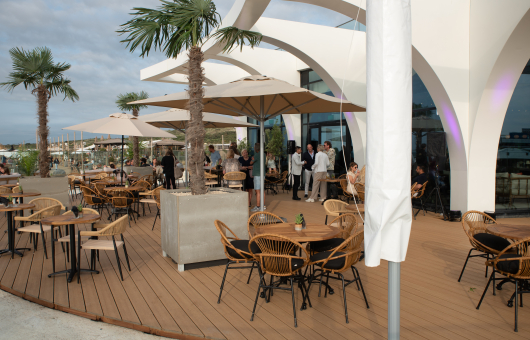 Terras van EVE met palmbomen en gezellige drukte