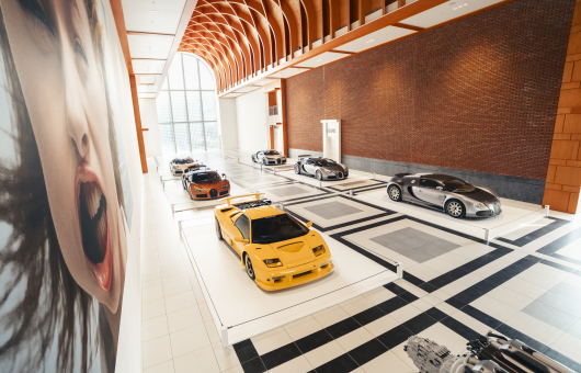 Zes luxe sportauto's in een moderne expositieruimte