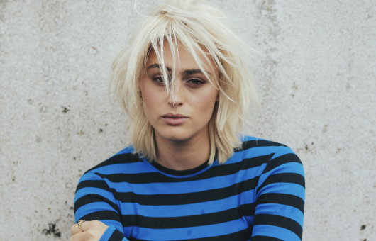 Porträt einer jungen Person mit blonden Haaren und gestreiftem Shirt