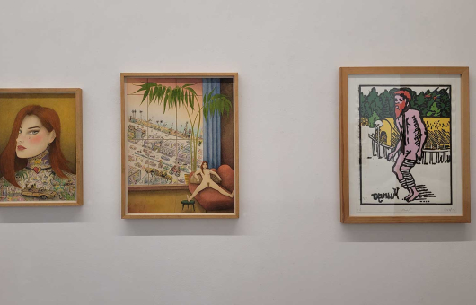 Drie kunstwerken aan de muur in een galerie.