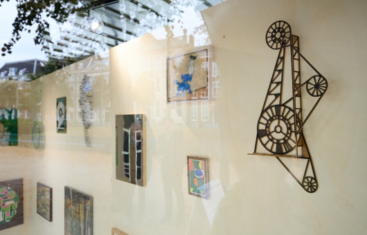 Verschillende kunstwerken hangen in een etalage.