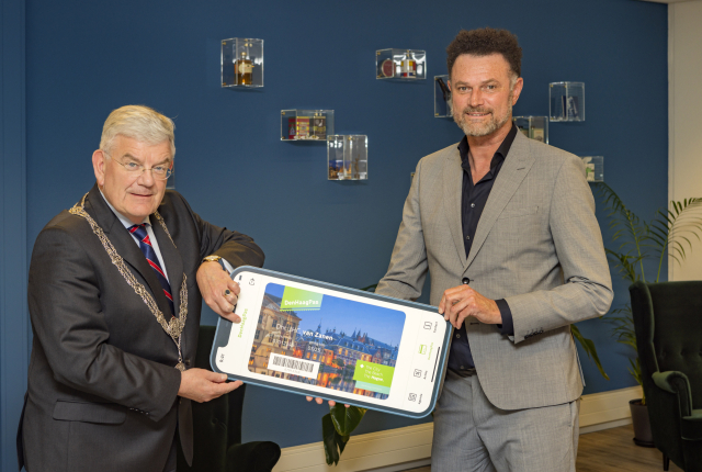 Burgemeester Van Zanen en Sander Hanenberg met de eerste DenHaagPas