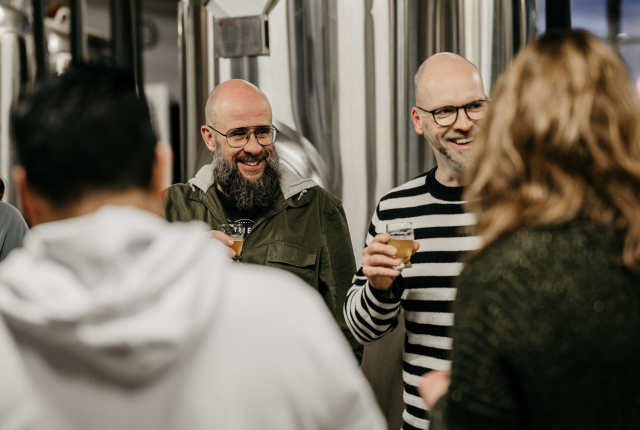 Deelnemers bij een bierproeverij met een bierglas 