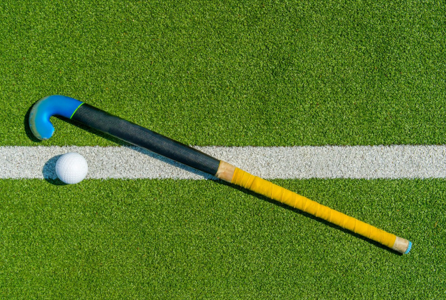 Foto van een hockeyveld met stick en bal
