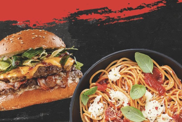 Een goed gevuld broodje cheeseburger en een bordje spaghetti met tomatensaus en baslicumblaadjes