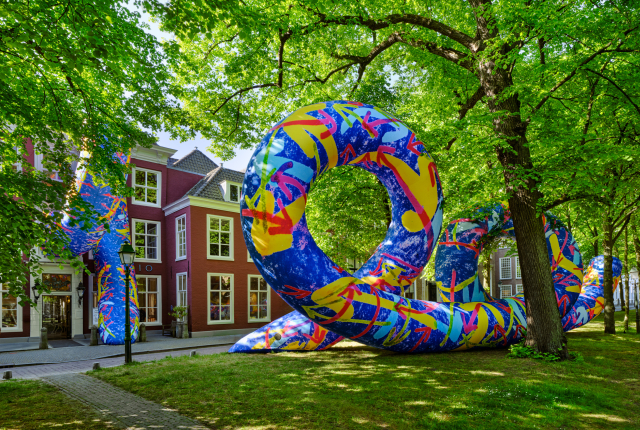 Kleurrijk kunstwerk op het Lange Voorhout tussen de bomen voor de gevel van Pulchri Studio