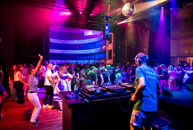 Dansende mensen met DJ achter draaitafel