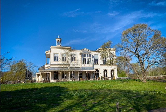 Koetshuis Ockenburgh stralend in de zon op Landgoed Ockenburgh