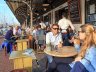 Zicht op restaurants en en mensen die een drankje drinken op terrassen langs de haven van Scheveningen op een zonnige dag