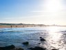 Het stille Zuiderstrand vanaf de zee gezien. Mensen wandelen langs de vloedlijn. 
