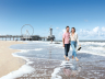 Koppel wandelt door de zee over het strand van Scheveningen