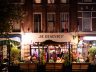 Drukke straat met mensen die zitten bij café De Regentes.