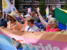 Groep mensen met een kleurrijke banner tijdens de Pride Parade. (c) COC Haaglanden