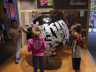 Kinderen luisteren naar de wereldbol met muziek
