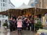 Een kerstkoor verleent een optreden onder een tent in Den Haag.