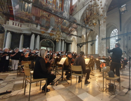 Koor en orkest tijdens uitvoering in monumentale kerk