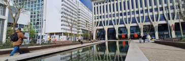 Een moderne architectuur met een waterpartij en bomen in Den Haag.