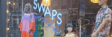 Swaps kledingwinkel etalage met kleurrijke outfits en mannequins